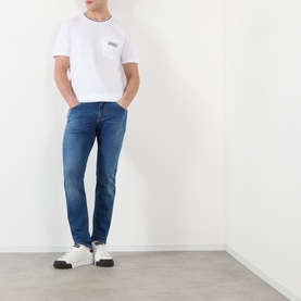 Model wearing Dolce & Gabbana Optical White Tipped Logo T-Shirt with chest pocket, styled with mid-blue slim jeans and white trainers.