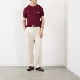 Model wearing Dolce & Gabbana Bordeaux Tipped Logo T-Shirt with chest pocket, styled with cream trousers and brown loafers.