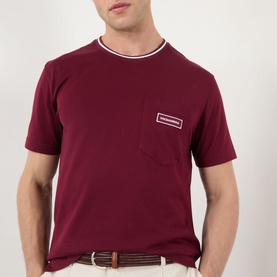 Model wearing Dolce & Gabbana Bordeaux Tipped Logo T-Shirt with chest pocket and logo badge, styled with a brown belt.
