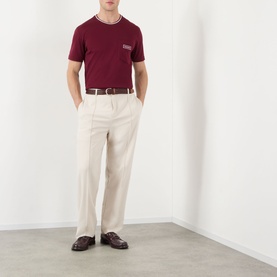 Model wearing Dolce & Gabbana Bordeaux Tipped Logo T-Shirt with cream wide-leg trousers and dark brown loafers.