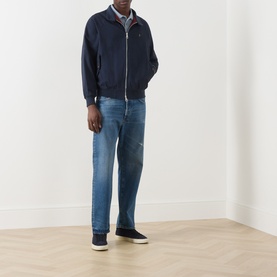 Model wearing Farah Vintage True Navy casual zip-up jacket, styled with mid-wash blue jeans and dark canvas shoes.