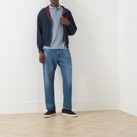 Model wearing Farah Vintage True Navy casual jacket with red trim, styled with a blue polo shirt and light-wash distressed jeans.