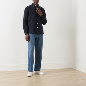Model wearing Farah Vintage True Navy casual shirt in 100% cotton, styled with blue jeans and white trainers