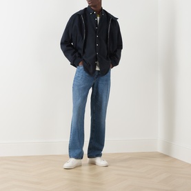 Model wearing Farah Vintage True Navy casual shirt, styled with dark bomber jacket, mid-wash straight-leg jeans and white trainers.