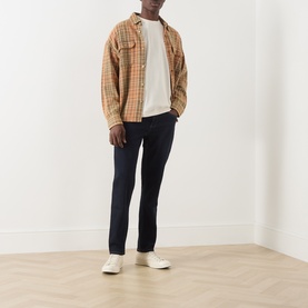 Model wearing Farah Vintage Ecru Crew Neck T-Shirt, styled with tan check overshirt, navy trousers and white trainers.