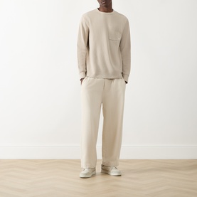 Model wearing Farah Vintage Putty Crew Neck T-shirt with matching wide-leg trousers and white trainers.