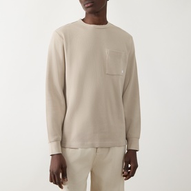 Model wearing Farah Vintage Putty Crew Neck T-shirt with chest pocket, styled with matching trousers.