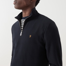 Model wearing Farah Vintage Navy Half Zip sweatshirt with gold logo, styled over a striped crew neck top.