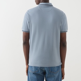 Model wearing Farah Vintage Icelandic Blue cotton polo shirt, back view, styled with light wash jeans.