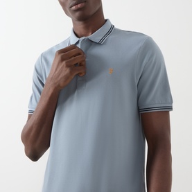 Model wearing Farah Vintage Icelandic Blue polo shirt with contrast tipped collar and cuffs, embroidered logo to chest.