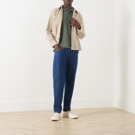 Model wearing Farah Vintage Putty Zip Through cotton jacket, styled with green polo shirt, blue jeans, and white trainers.