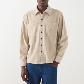 Model wearing Farah Vintage putty cotton casual shirt with chest pockets and button front, styled with blue jeans.