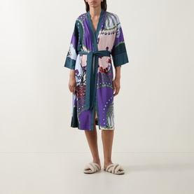 Model wearing Mey Mystic Jade Kimono in multicolour print with teal trim and self-tie belt, styled with fluffy slippers.
