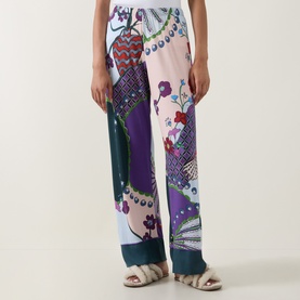 Model wearing Mey Mystic Jade PJ Pants in multicolour peacock and floral print, styled with white sandals