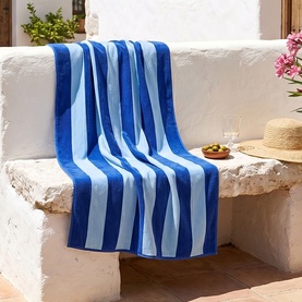 Misona Beach Towel Navy Sky draped over a white stone bench, bold navy and sky blue stripes, 100% cotton jacquard