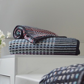 Odyssey Carnival Towel Black, 100% cotton jacquard beach towel in black with multicolour check pattern, shown folded and stacked