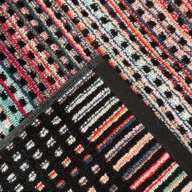 Odyssey Carnival Towel Black, 100% cotton jacquard beach towel showing multicolour stripe and dot pattern with folded corner detail