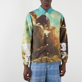 Model wearing Pleasures multi-colour scenic-print casual jacket with blue collar, styled with light blue jeans