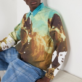 Model wearing Pleasures multi-colour printed casual jacket with scenic landscape graphic, styled with light wash jeans
