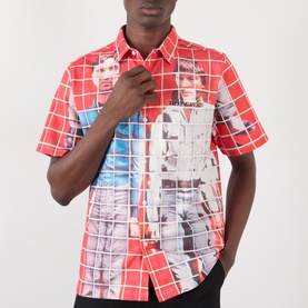 Model wearing Pleasures More Songs About Buildings and Food Check Shirt in red with graphic photo print, short sleeves, and pointed collar.