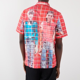 Model wearing Pleasures More Songs About Buildings and Food Check Shirt in red with graphic photo print, short sleeves, and check pattern, back view.