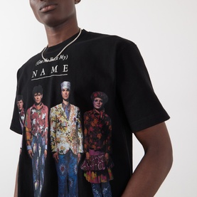 Model wearing Pleasures Creatures of Love Logo Graphic T-Shirt in black with figure print and text graphic, styled with a silver chain necklace.