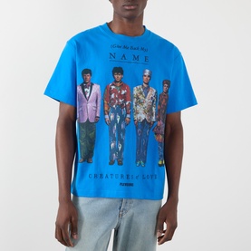 Model wearing Pleasures Creatures of Love Logo Graphic T-Shirt in blue with four-figure graphic print, paired with light-wash jeans.