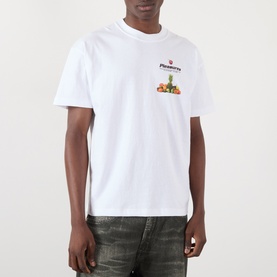 Model wearing Pleasures Delivery Back Graphic Logo T-Shirt in white, with small fruit graphic and logo print on chest, crew neck, short sleeves.