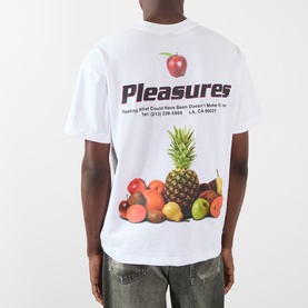 Model wearing Pleasures Delivery Back Graphic Logo T-Shirt in white, featuring fruit print and logo graphic, with grey distressed jeans.