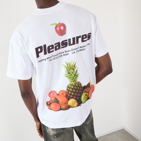 Model wearing Pleasures Delivery Back Graphic Logo T-Shirt in white, featuring fruit graphic and logo print on back, round neck, short sleeves.