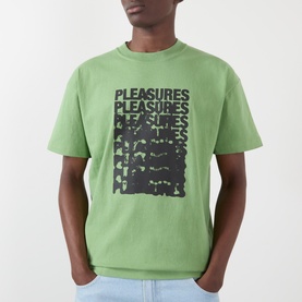 Model wearing Pleasures Immolate Logo Graphic T-Shirt in sage green with repeat black graphic print to chest, styled with light blue jeans.