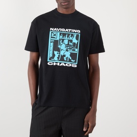 Model wearing Pleasures Navigating Chaos Logo Graphic T-Shirt in black with cyan graphic print, styled with pinstripe trousers.