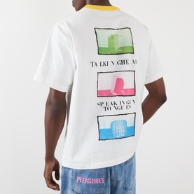 Model wearing Pleasures Speaking Logo Graphic T-Shirt in white, back view showing colourful graphic print and contrast yellow collar.