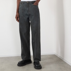 Model wearing Pleasures black wide-leg jeans in 100% cotton, styled with chunky black leather shoes