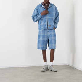 Model wearing Pleasures Logo Check Denim Zip Hoodie in blue check, styled with matching denim shorts and grey trainers.