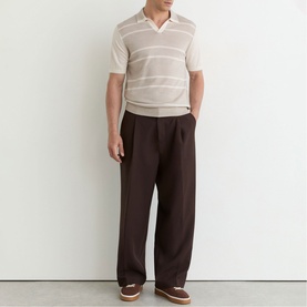 Model wearing Reiss beige striped short-sleeve knit polo with open collar, styled with dark brown wide-leg trousers and brown loafers.