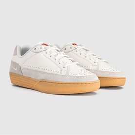 Nike trainer in Sail colourway with suede and leather panels, red tab detail, and honey gum sole. Low-top lace-up silhouette.