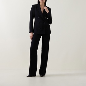 Model wearing Akris Punto black double-breasted blazer, styled with matching wide-leg trousers and black heels.