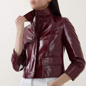 Model wearing Akris Punto pomegranate patent leather jacket with zip fastening, front pockets and high collar