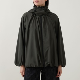 Model wearing Akris Punto olive parka with gathered hood and blouson sleeves, styled with dark wide-leg trousers