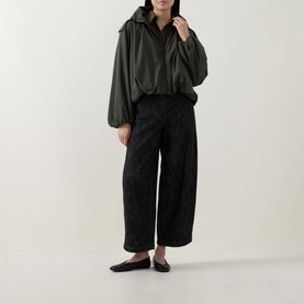 Model wearing Akris Punto olive parka with oversized silhouette, styled with black wide-leg trousers and flat ballet shoes