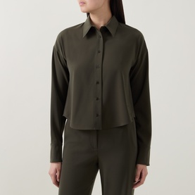 Model wearing Akris Punto olive cropped shirt with long sleeves and button front, styled with matching olive trousers.
