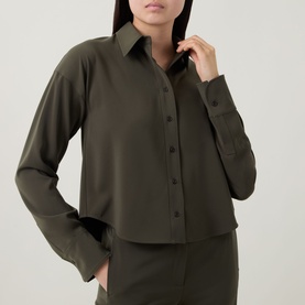 Model wearing Akris Punto olive shirt with button front, long sleeves and wide cuffs, styled with matching olive trousers.