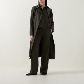 Model wearing Akris Punto olive shirt styled with matching wide-leg trousers and long coat in tonal khaki, with black shoes.