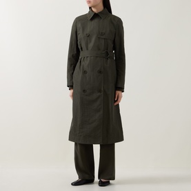 Model wearing Akris Punto olive trench coat, double-breasted with belt, styled with wide-leg trousers and flat shoes