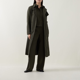 Model wearing Akris Punto Olive Trench Coat, styled with matching olive wide-leg trousers and black shirt, black shoes.