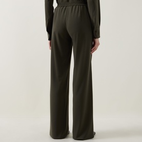 Model wearing Akris Punto olive wide-leg trousers, rear view, styled with matching olive long-sleeve top.