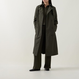 Model wearing Akris Punto olive trousers, styled with matching olive coat and black shirt, black flat shoes.