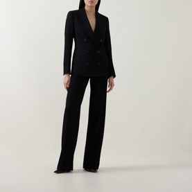 Model wearing Akris Punto black wide-leg trousers, styled with a matching black double-breasted blazer.