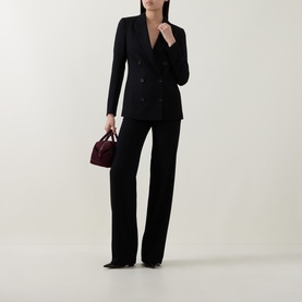 Model wearing Akris Punto black wide-leg trousers, styled with a matching black double-breasted blazer and burgundy handbag.